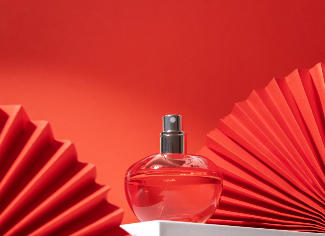 prikaz crvene bočice parfema na crvenoj pozadini