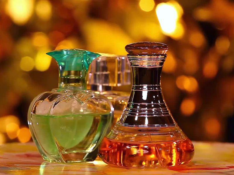 prikaz tri različita parfema na drvenom stolčiću