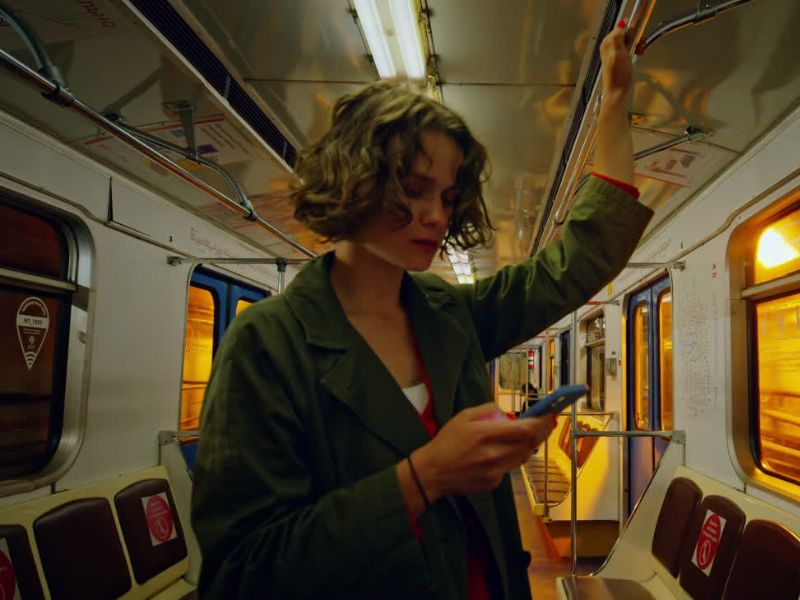 Devojka kraće kose stoji u metrou