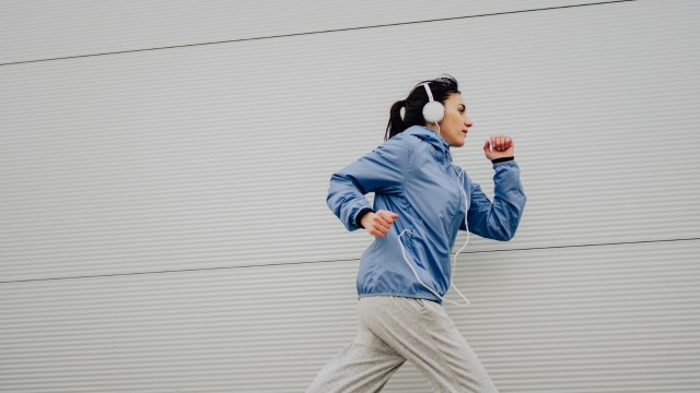 Žena sa slušalicama trči napolju