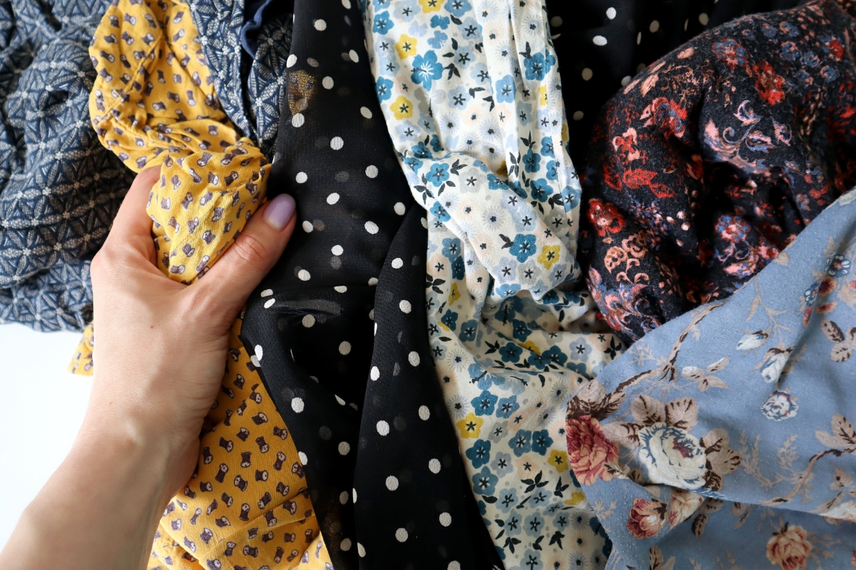 prikaz devojke koja drži u ruci nekoliko materijala odeće