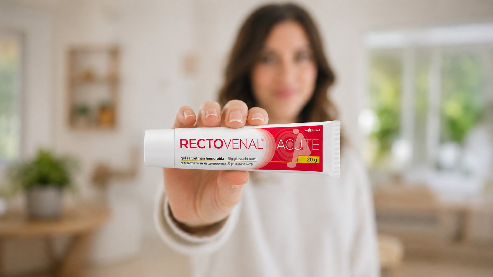Žena u ispruženoj ruci drži tubu RECTOVENAL® Acute anorektalnog gela za ublažavanje simptoma hemoroidalne bolesti.