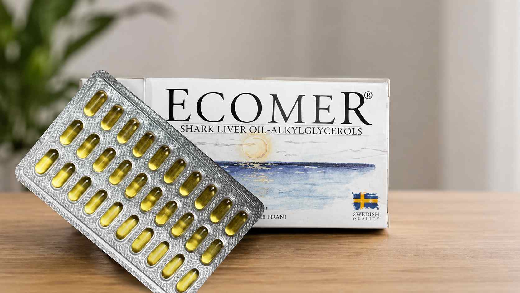 Ecomer kutija i blister sa kapsulama na drvenom stolu.